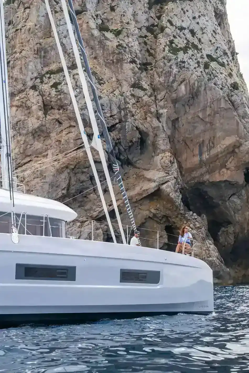 A Lagoon 60 close under a headland